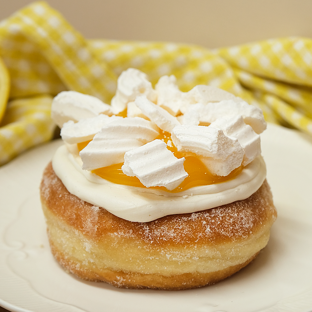 A single doughnut with lemon curd and meringue on top in a Newbury bakery