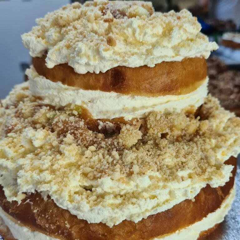 A giant doughnut cake topped with buttercream and crumble