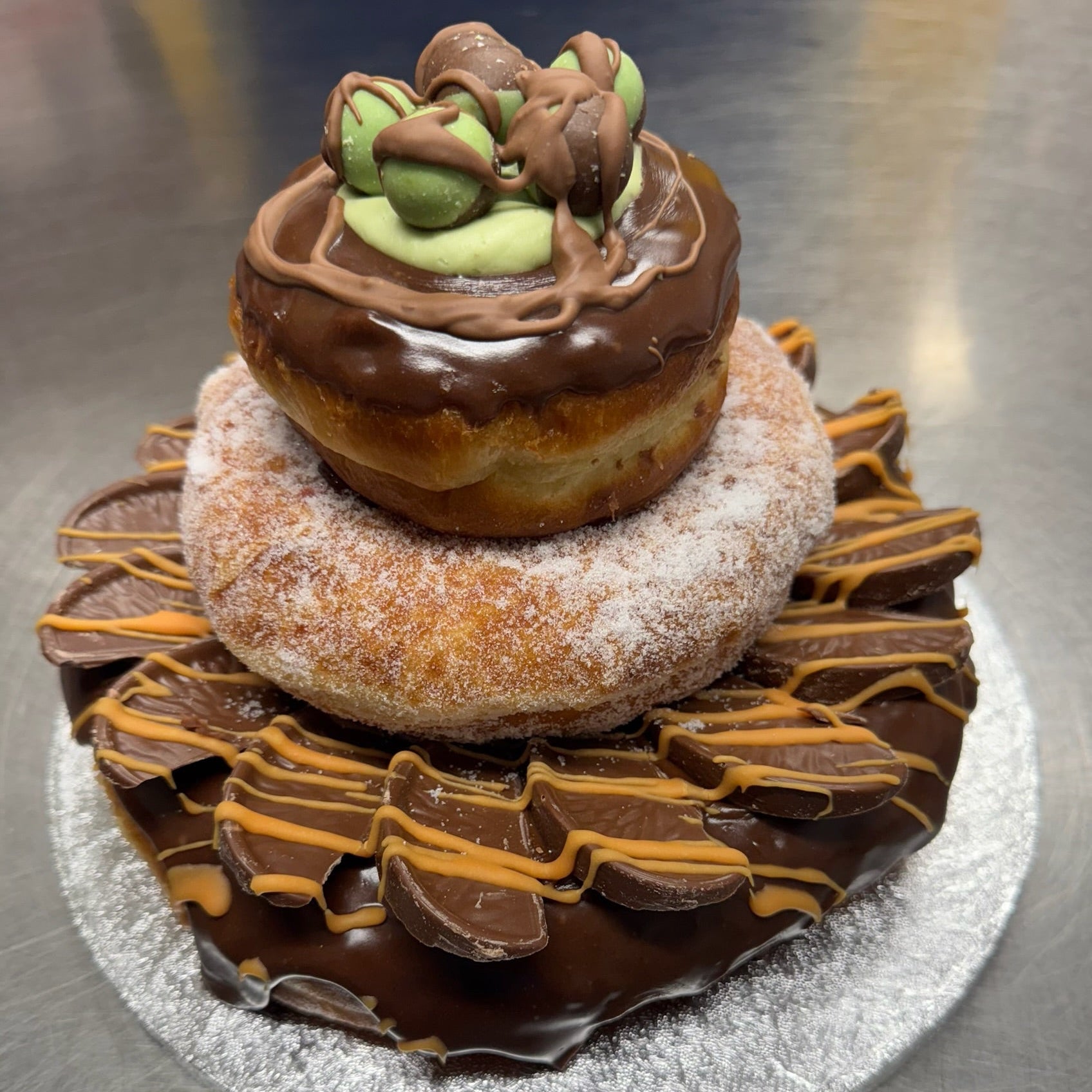 A large tiered cake made from giant doughnuts with chocolate orange and aero topping