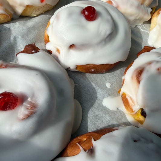Large iced buns with a cherry on top