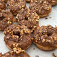 Donuts with chocolate glaze and nuts on a white surface