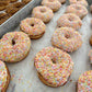 Sprinkled doughnuts on a baking tray