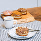Peanut Choco Crunch ring doughnut with caramel icing, chocolate drizzle, and crunchy peanut brittle