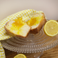 A lemon knot cut in half with lemon curd oozing out of it on a cake stand