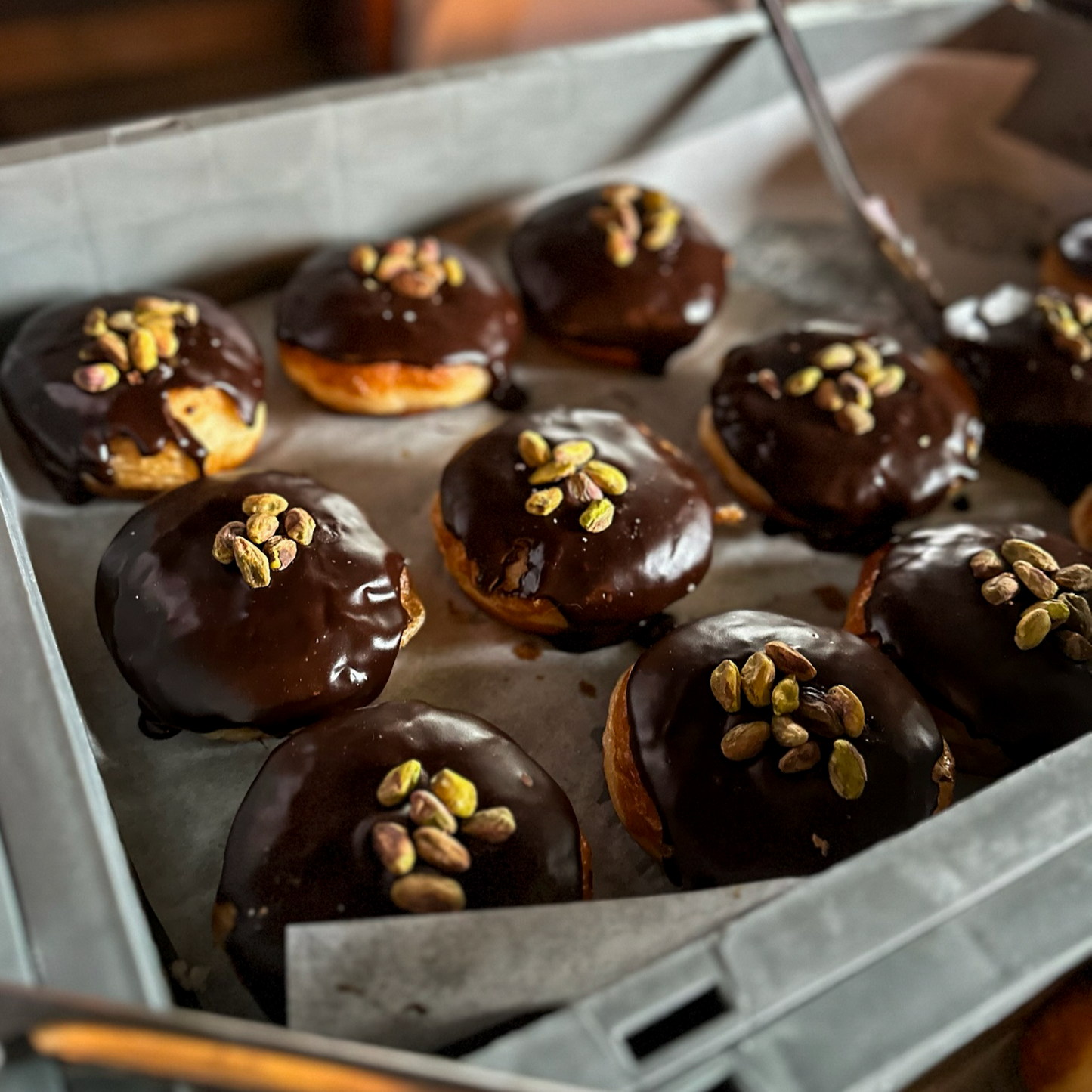 chocolate-covered doughnuts with pistachios in a box